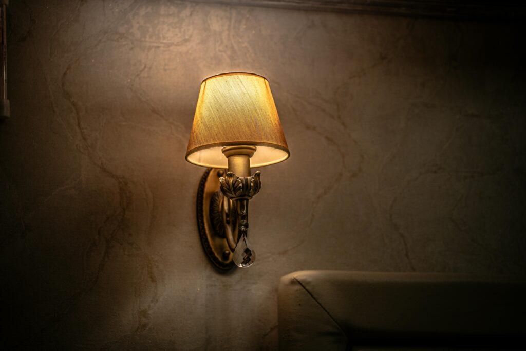 Vintage wall sconce casting a warm and cozy glow in an indoor setting, perfect for ambiance.